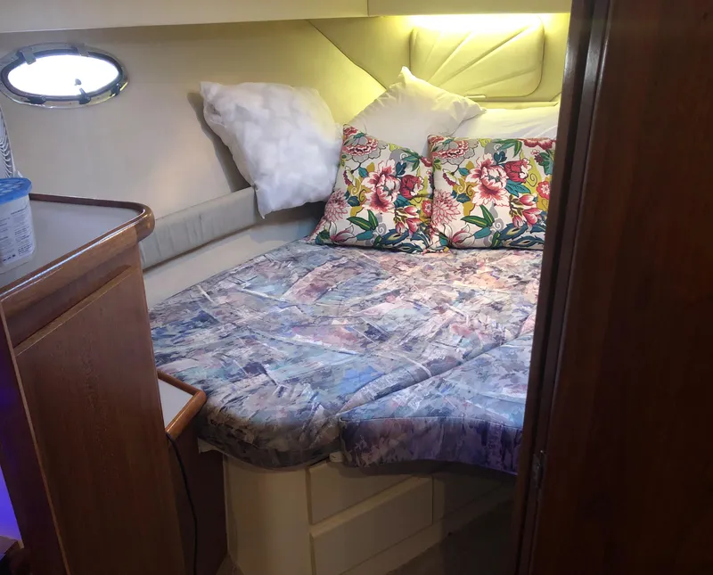 Slide: The Image of 1996 Carver 355 Aft Cabin bedroom with floral pillows and cozy bedding. - 44