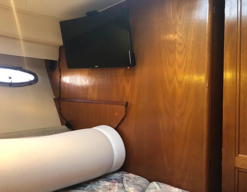 Slide: The Image of 1996 Carver 355 Aft Cabin interior with TV and wooden paneling. - 46