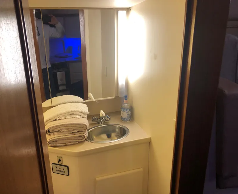 Slide: The Image of 1996 Carver 355 Aft Cabin bathroom with sink, mirror, and towels. - 48