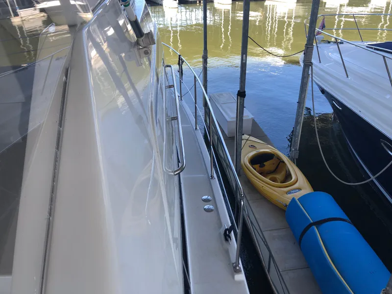 Slide: The Image of 1996 Carver 355 Aft Cabin yacht docked with kayak and blue float nearby. - 8