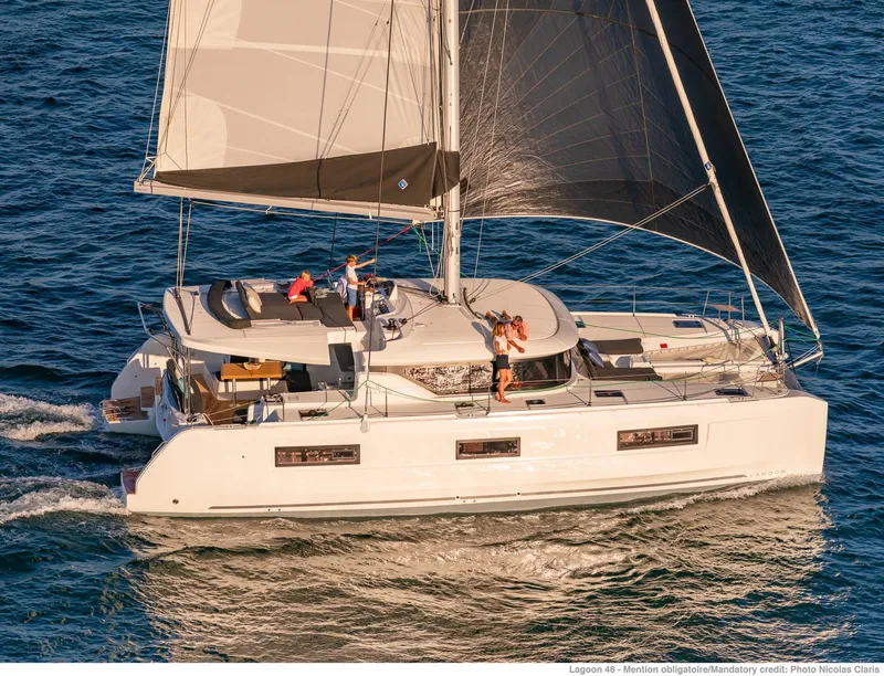 Slide: The Image of 2025 Lagoon 46 ICONIC catamaran sailing on open water with crew on deck. - 2