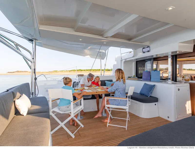 Slide: The Image of Family enjoying a meal on the deck of a 2025 Lagoon 46 ICONIC catamaran. - 9