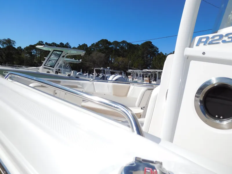 Slide: The Image of 2025 Robalo R232 Explorer boat, white exterior, docked under clear blue sky. - 3