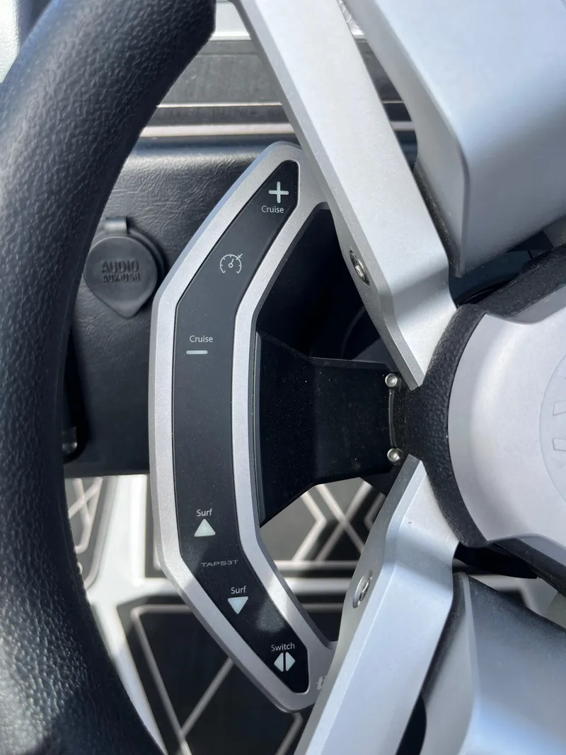 Slide: The Image of Steering wheel controls of 2023 Tigé 22RZX boat, featuring cruise and surf settings. - 24