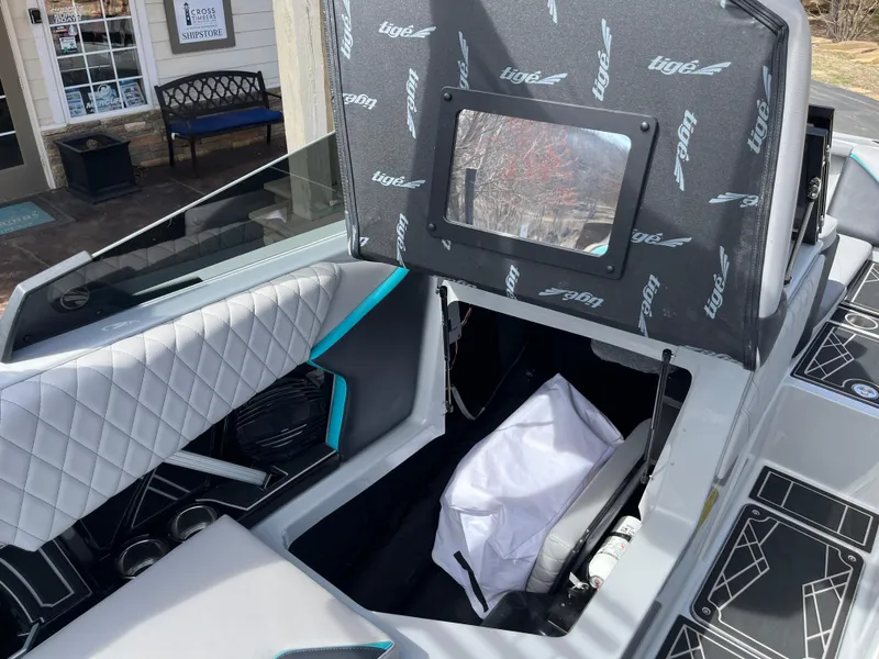 Slide: The Image of 2023 Tigé 22RZX boat interior with open storage compartment and quilted seating. - 30