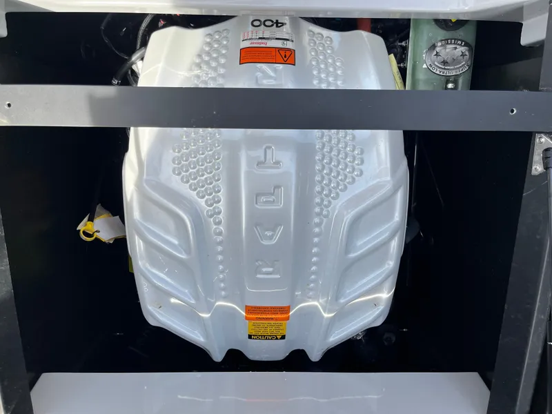 Slide: The Image of Engine compartment of a 2023 Tigé 22RZX boat, featuring a sleek white engine cover. - 31