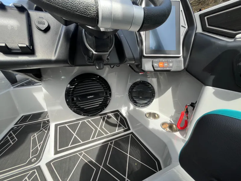 Slide: The Image of 2023 Tigé 22RZX boat interior with steering wheel, touchscreen, and speakers. - 35