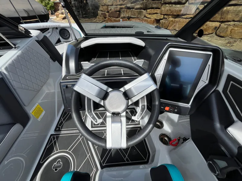 Slide: The Image of 2023 Tigé 22RZX boat dashboard with modern steering wheel and touchscreen display. - 36