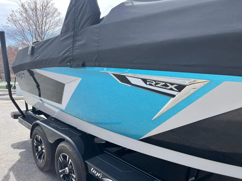 Slide: The Image of 2023 Tigé 22RZX boat with blue and black design on a trailer. - 9