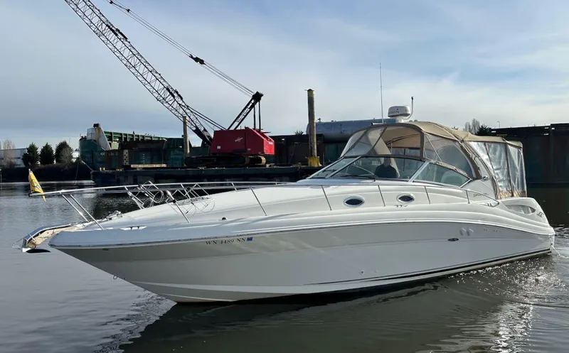 Slide: The Image of 2004 Sea Ray 340 Sundancer boat docked in a marina with industrial background. - 0