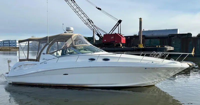 Slide: The Image of 2004 Sea Ray 340 Sundancer yacht on calm water near industrial backdrop. - 10