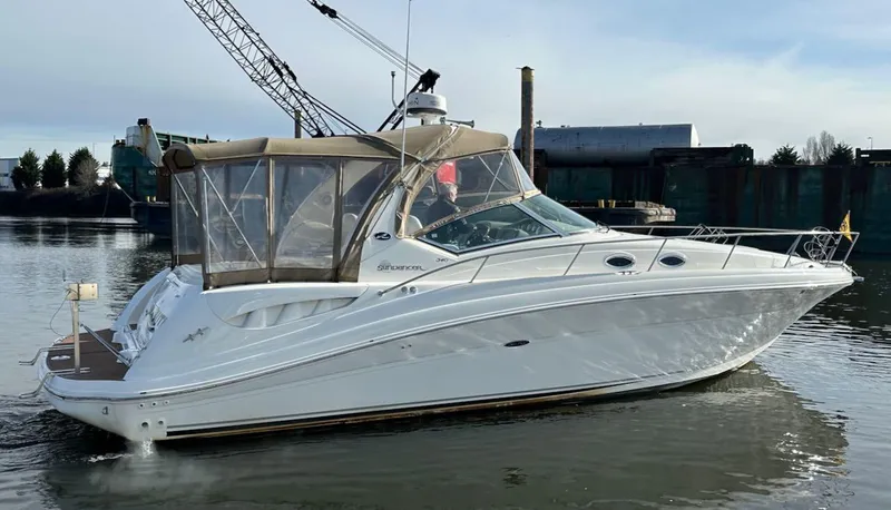 Slide: The Image of 2004 Sea Ray 340 Sundancer boat on calm water, featuring sleek design and beige canopy. - 11