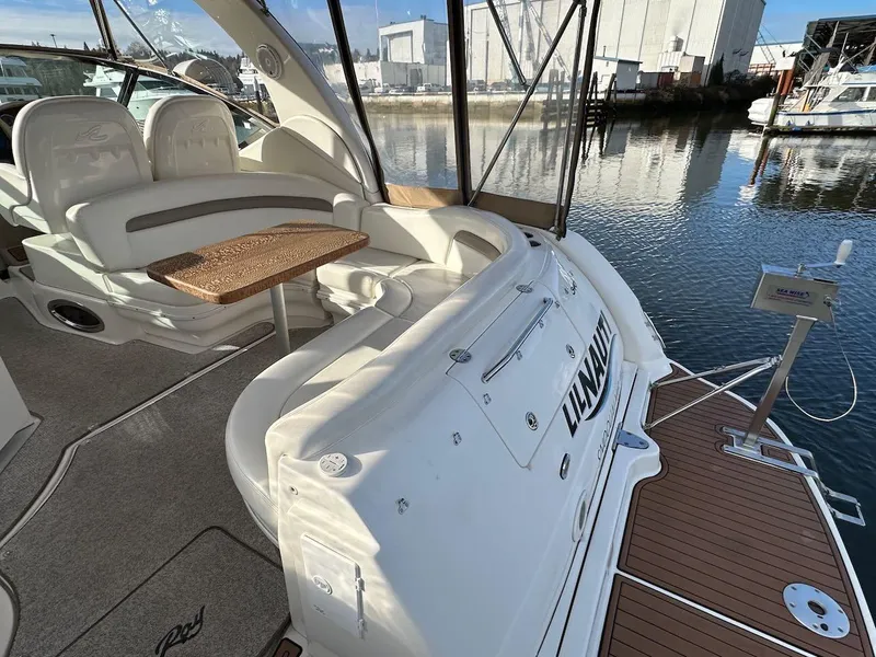 Slide: The Image of 2004 Sea Ray 340 Sundancer yacht interior with seating and table, docked by the water. - 22