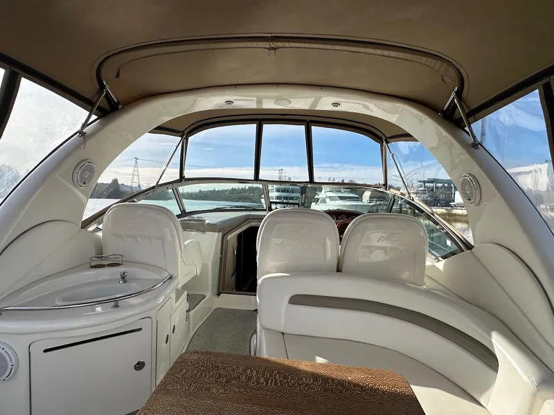 Slide: The Image of 2004 Sea Ray 340 Sundancer interior with seating and helm, featuring panoramic windows. - 26