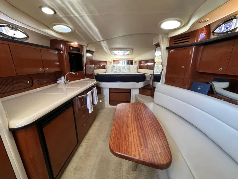 Slide: The Image of 2004 Sea Ray 340 Sundancer interior with kitchen, seating, and bed. Luxurious yacht cabin design. - 36