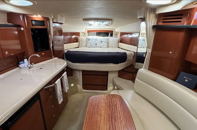 Slide: The Image of Luxurious interior of 2004 Sea Ray 340 Sundancer yacht with bed, kitchenette, and seating area. - 37