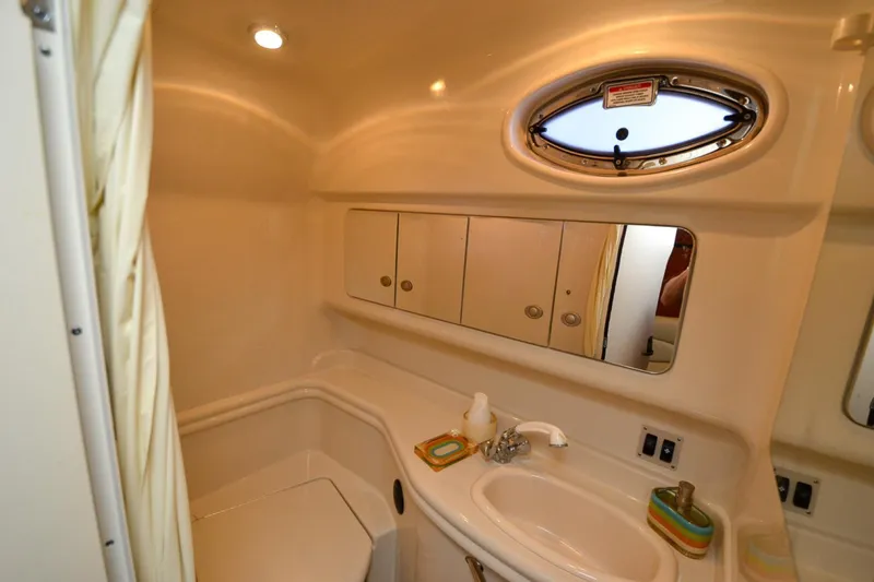 Slide: The Image of 2004 Sea Ray 340 Sundancer bathroom with sink, mirror, and porthole window. - 46