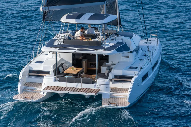 Slide: The Image of 2025 Lagoon 51 ICONIC catamaran sailing on open sea, featuring spacious deck and modern design. - 17