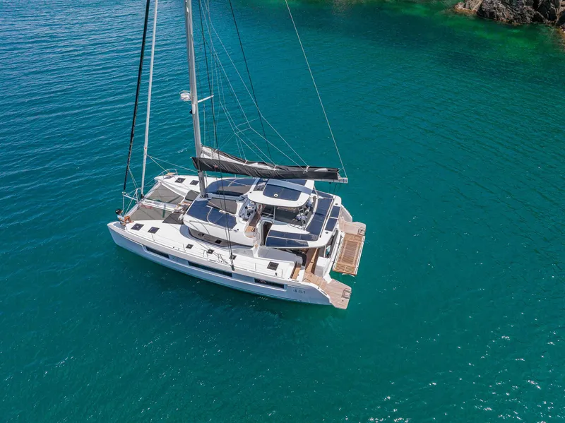 Slide: The Image of 2025 Lagoon 51 ICONIC catamaran sailing on clear blue water. - 5