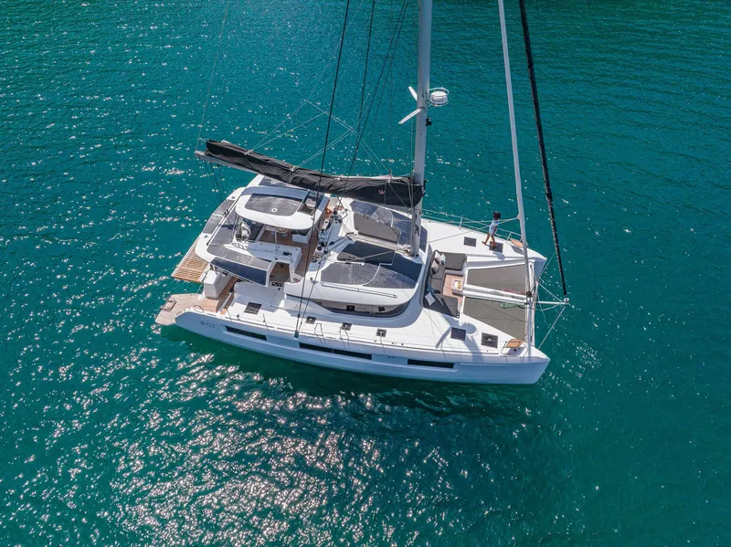 Slide: The Image of 2025 Lagoon 51 ICONIC catamaran sailing on clear blue water. - 7