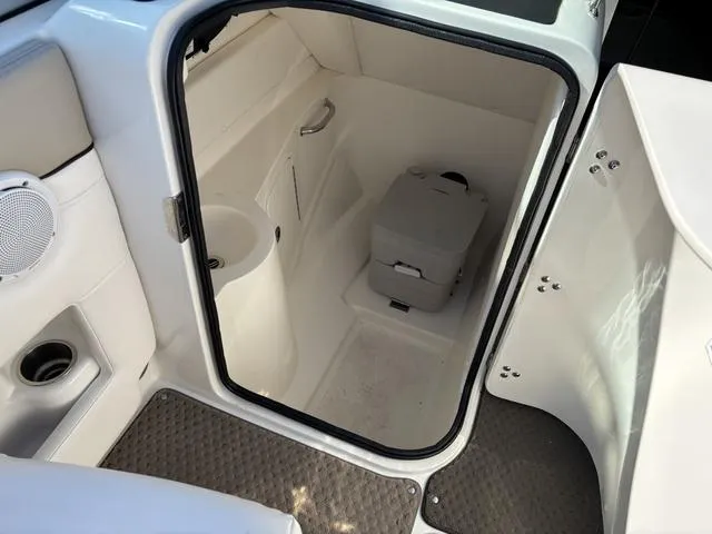 Slide: The Image of 2011 Sea Ray 260 Sundeck interior with compact marine toilet and storage space. - 15