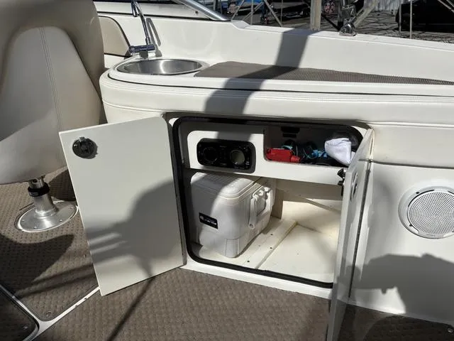 Slide: The Image of 2011 Sea Ray 260 Sundeck interior with open storage compartment and sink. - 18