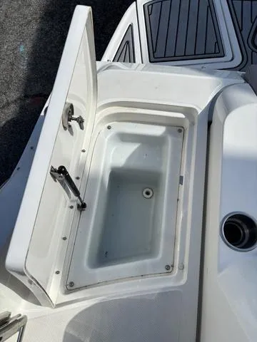 Slide: The Image of 2011 Sea Ray 260 Sundeck storage compartment with open lid, showcasing interior space. - 21
