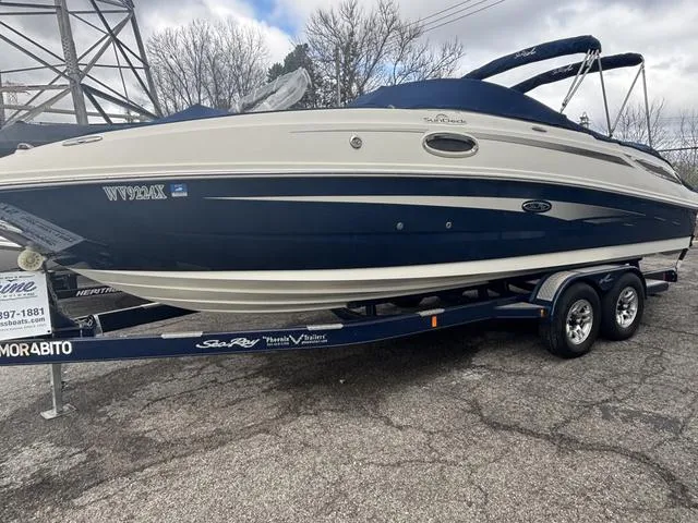 Slide: The Image of 2011 Sea Ray 260 Sundeck cockpit with steering wheel and gauges, featuring beige seating. - 3