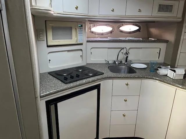 Slide: The Image of 1998 Maxum 4100 SCR yacht kitchen with microwave, stove, sink, and storage cabinets. - 5