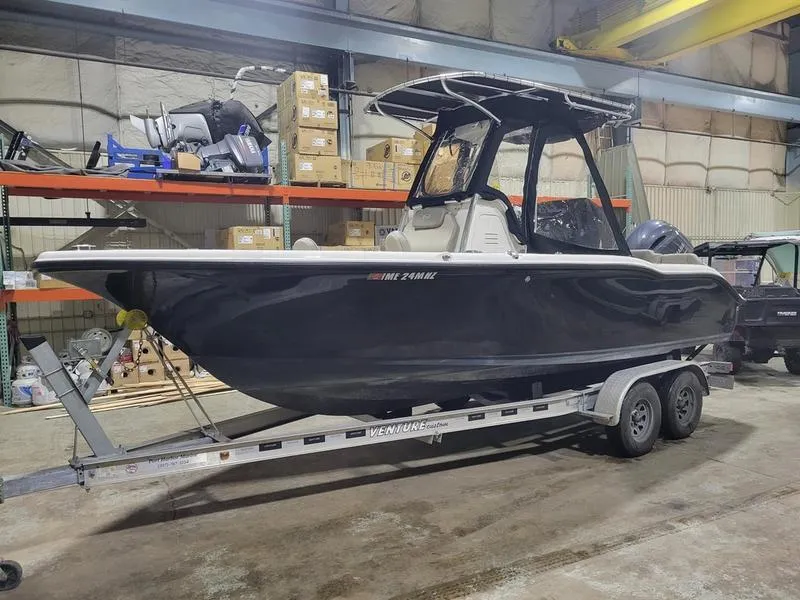 Slide: The Image of 2022 Key West 219fs boat on trailer in warehouse setting. - 1