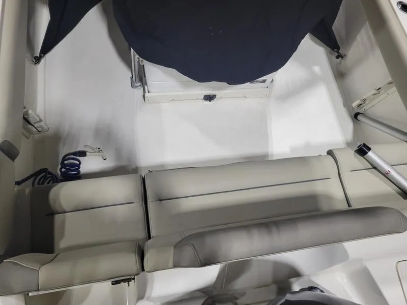 Slide: The Image of 2022 Key West 219fs boat interior with cushioned seating and storage compartments. - 10