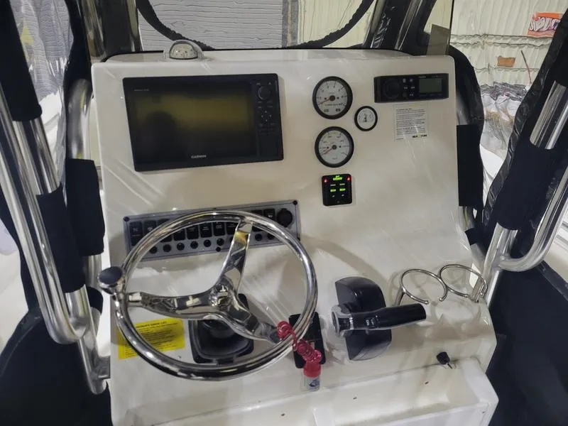 Slide: The Image of 2022 Key West 219fs boat dashboard with steering wheel, gauges, and navigation system. - 11