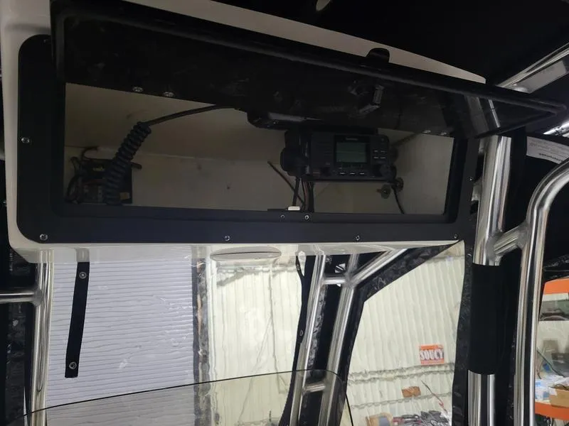 Slide: The Image of 2022 Key West 219fs boat interior with radio equipment and storage compartment. - 12