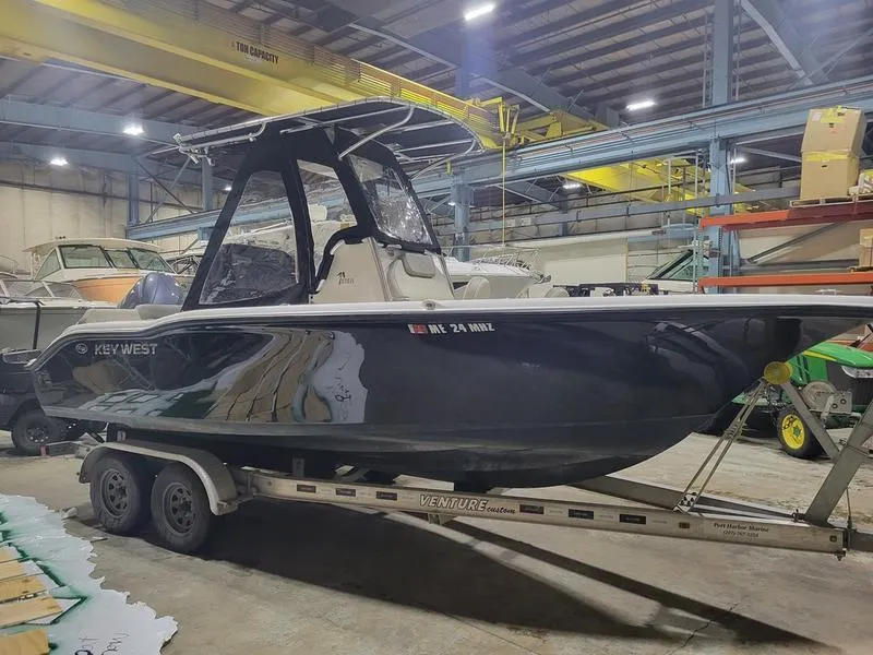 Slide: The Image of 2022 Key West 219fs boat on trailer in warehouse setting. - 3