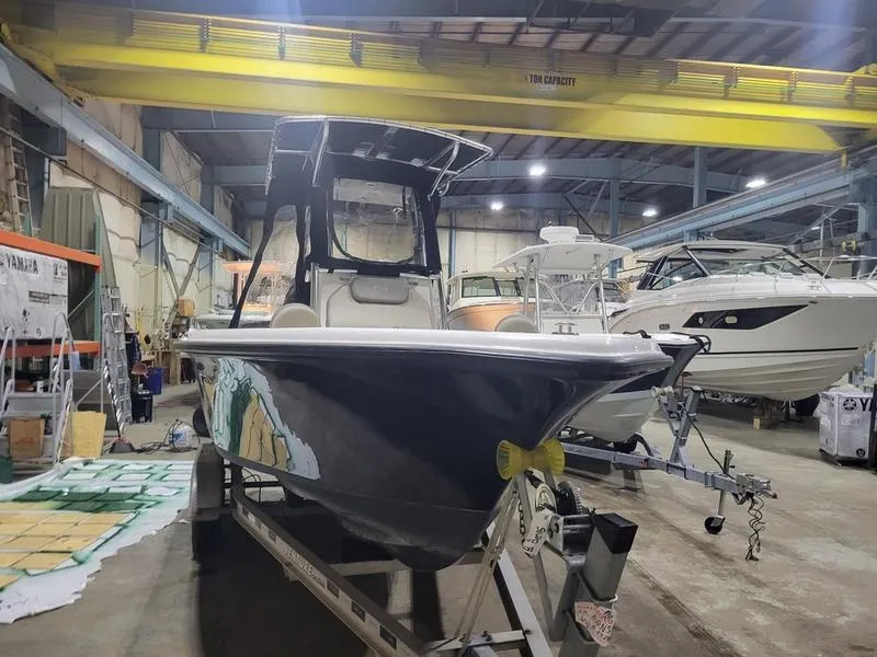 Slide: The Image of 2022 Key West 219fs boat in a warehouse, on a trailer, with other boats nearby. - 5