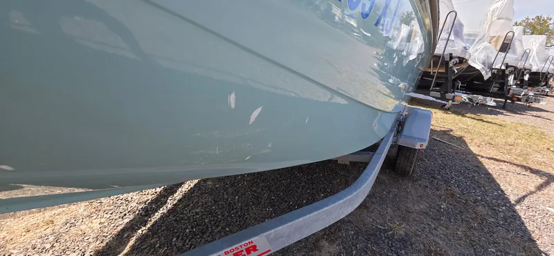 Slide: The Image of 2024 Boston Whaler 160 Super Sport boat on trailer, side view, outdoors. - 10