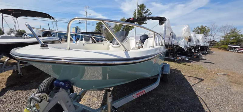 Slide: The Image of 2024 Boston Whaler 160 Super Sport boat on trailer, displayed outdoors under clear sky. - 9