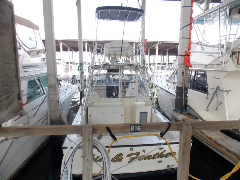 Slide: The Image of 1999 Albemarle 320 Express boat docked in a marina, surrounded by other vessels. - 0