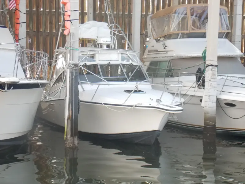 Slide: The Image of 1999 Albemarle 320 Express boat docked between other vessels in a marina. - 1