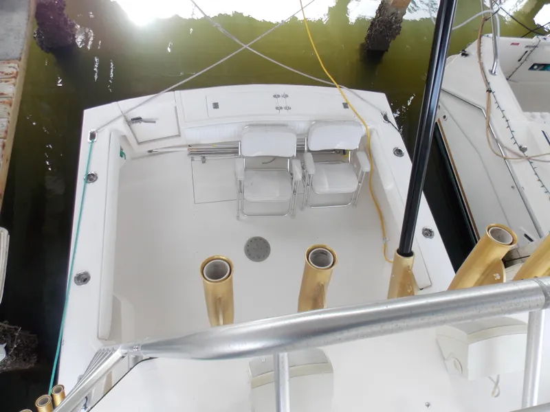 Slide: The Image of 1999 Albemarle 320 Express boat deck with seating and fishing rod holders. - 11