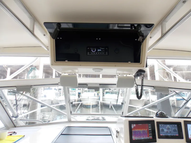 Slide: The Image of 1999 Albemarle 320 Express boat cockpit with navigation equipment and overhead storage. - 12