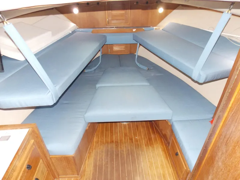 Slide: The Image of 1999 Albemarle 320 Express cabin interior with blue cushioned seating and wooden flooring. - 13