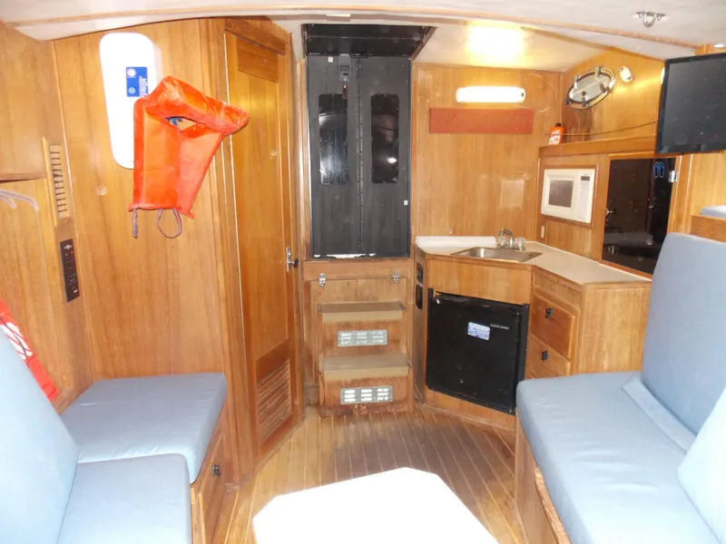 Slide: The Image of 1999 Albemarle 320 Express cabin interior with seating, kitchenette, and wooden finishes. - 15