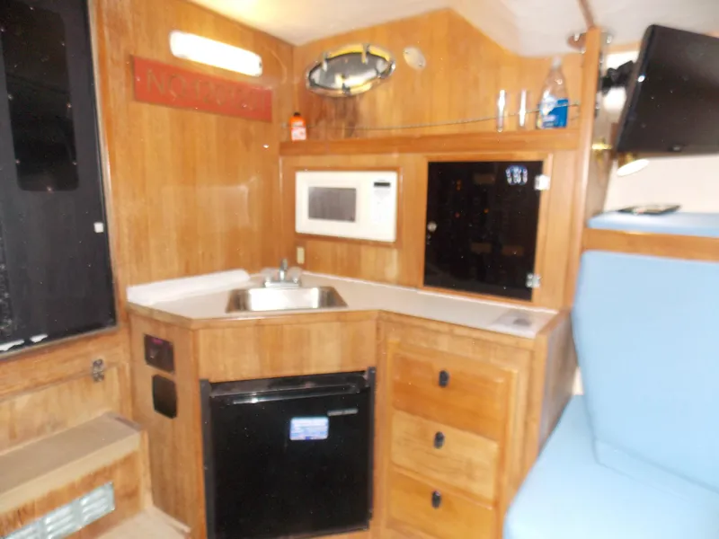 Slide: The Image of Interior of 1999 Albemarle 320 Express boat with kitchenette, sink, microwave, and storage. - 16