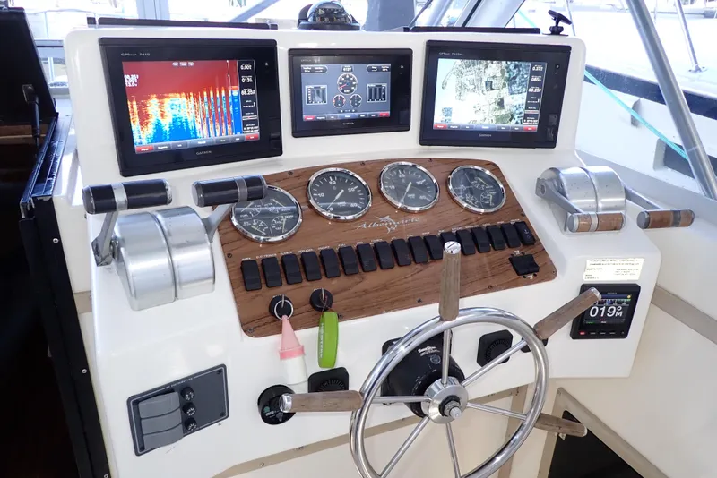 Slide: The Image of Control panel of a 1999 Albemarle 320 Express boat with navigation screens and gauges. - 18