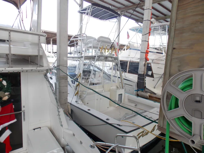 Slide: The Image of 1999 Albemarle 320 Express boat docked in a marina, surrounded by other vessels. - 2