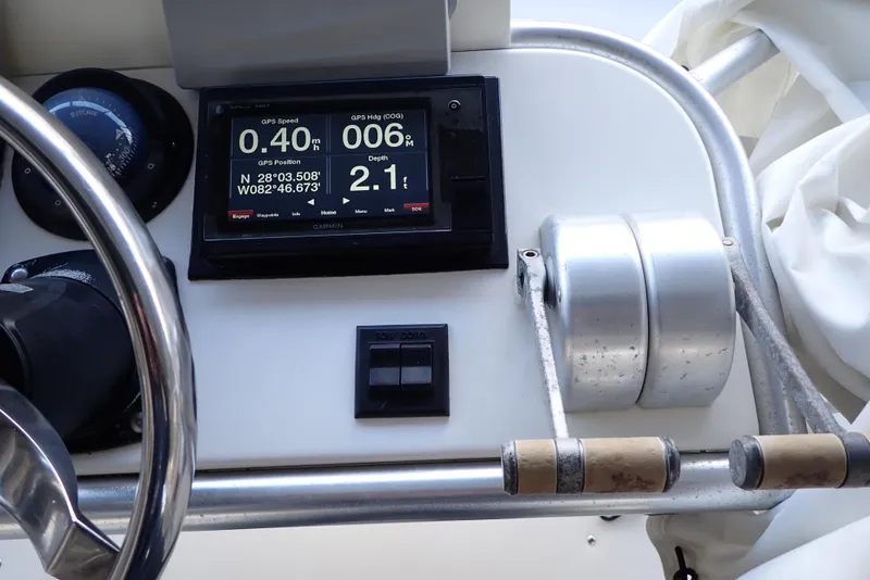 Slide: The Image of 1999 Albemarle 320 Express dashboard with navigation display and throttle controls. - 24