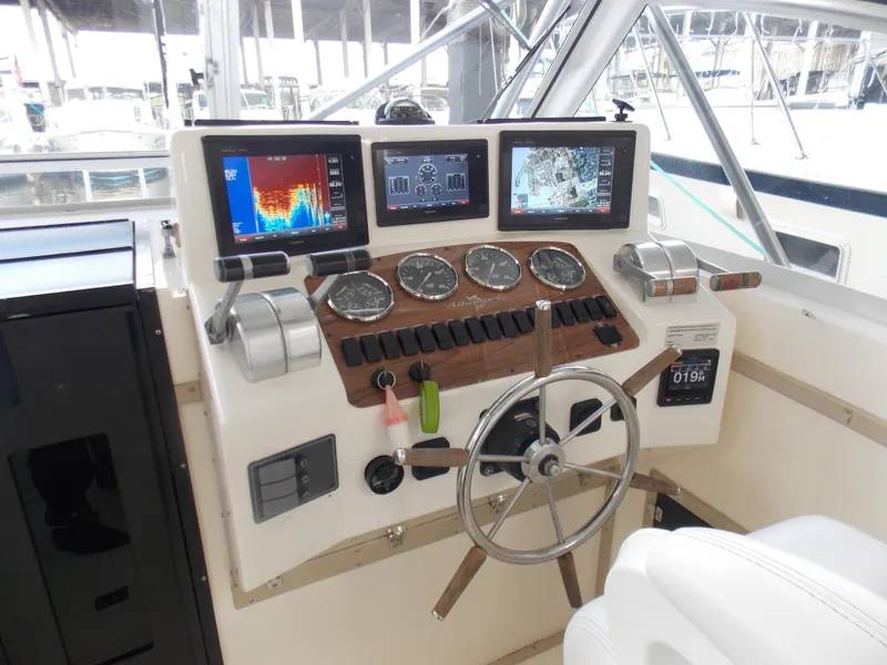 Slide: The Image of 1999 Albemarle 320 Express helm with navigation screens and controls. - 3