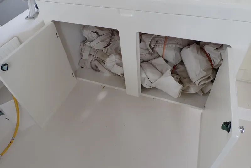 Slide: The Image of Open storage compartment on 1999 Albemarle 320 Express boat with stored items. - 35