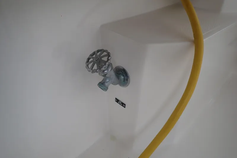 Slide: The Image of Yellow hose connected to a metal valve on a 1999 Albemarle 320 Express boat. - 40